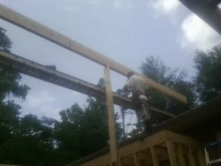 Carpenter setting a ridge beam over a new addition frame — Ice Dam Removal by Roofing Brothers in Shenandoah Junction